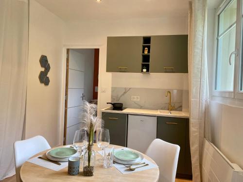 une salle à manger avec une table et des chaises ainsi qu'une cuisine dans l'établissement Studio tout juste rénové, à Dijon