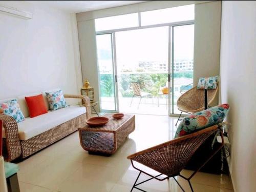 a living room with a couch and chairs at * * Magnífico * * apto en la playa * *Costazul 405 in Santa Marta