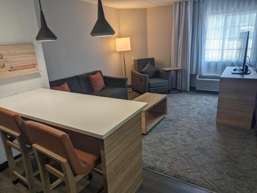 a hotel room with a bar and a living room at Candlewood Suites Wilson by IHG in Wilson