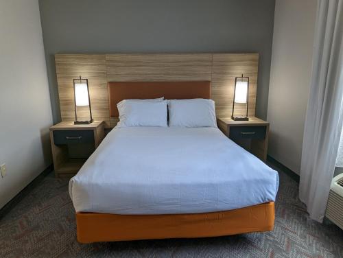 1 dormitorio con 1 cama grande y 2 lámparas en ambos lados en Candlewood Suites Wilson, an IHG Hotel en Wilson