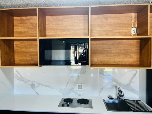 a kitchen with wooden cabinets and a sink at North Villa extended stay in Houston
