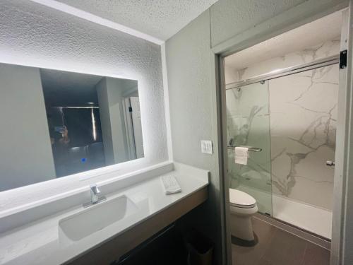 Un baño con lavabo, inodoro y espejo. en North Villa extended stay, en Houston