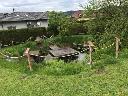 a small pond with a wooden bridge in a yard at Klopeinerperle in Peratschitzen