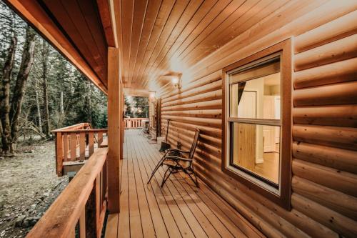 drewniany ganek kabiny z krzesłem w obiekcie 02GS - Hot Tub - WiFi - D W - WithD - Sleeps 8 home w mieście Glacier