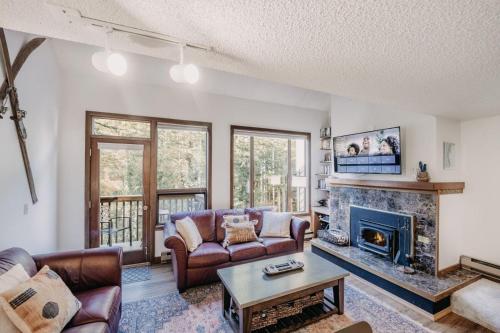 ein Wohnzimmer mit Couch und Kamin in der Unterkunft 55SW - Fireplace - D W - WithD - Sleeps 4 condo in Glacier