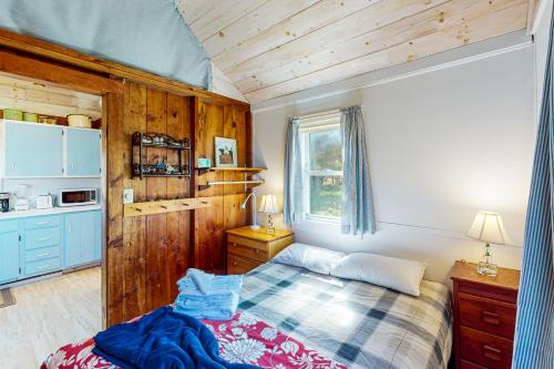 1 dormitorio con 1 cama en una habitación con paredes de madera en North Truro Bayside Gem, en Truro
