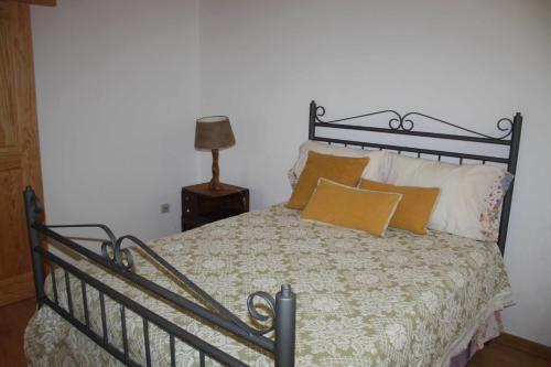 a bedroom with a bed with yellow pillows at Quinta do Casal da Bica 