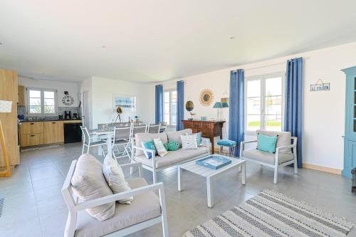 ein Wohnzimmer mit weißen Möbeln und eine Küche in der Unterkunft Magnificent Villa recent quiet St Denis D'Oléron in Saint-Denis-dʼOléron