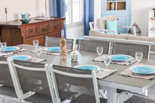 a dining room table with a bottle of wine on it at Magnificent Villa recent quiet St Denis D'Oléron in Saint-Denis-dʼOléron