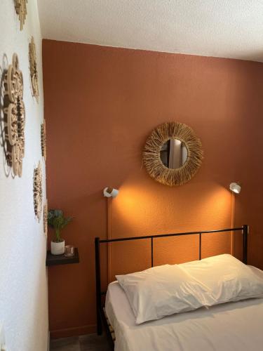 Schlafzimmer mit einem Bett und einem Spiegel an der Wand in der Unterkunft Appartement Argelès-sur-Mer avec piscine à 500m de la mer in Argelès-sur-Mer