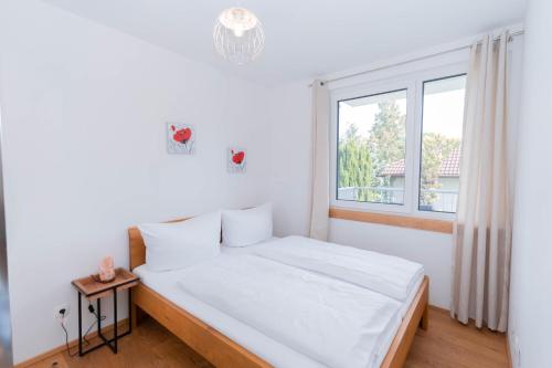 Habitación blanca con cama y ventana en Modern apartment with private balcony near city center, en Viena