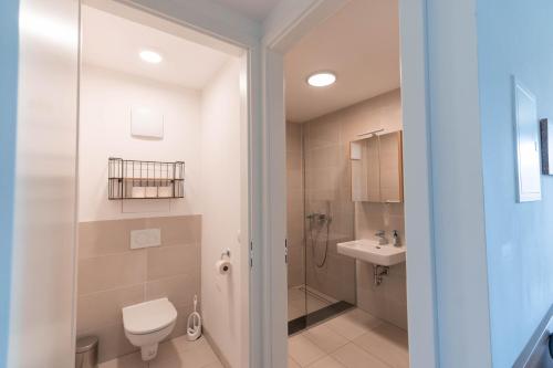 y baño con ducha, aseo y lavamanos. en Modern apartment with private balcony near city center, en Viena