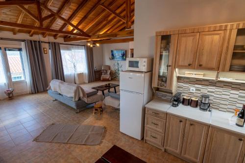 eine Küche mit einem Kühlschrank und ein Wohnzimmer in der Unterkunft Villa George in Skiathos in Skiathos-Stadt