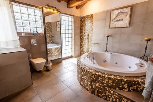 ein großes Bad mit einer Badewanne und einem WC in der Unterkunft Villa George in Skiathos in Skiathos-Stadt