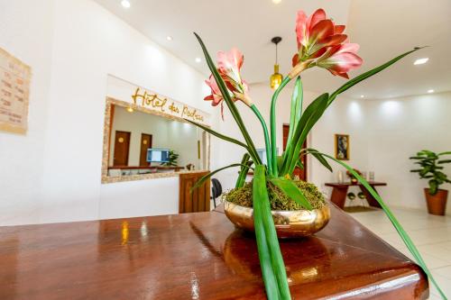 um vaso cheio de flores em cima de uma mesa em OYO Hotel Das Pedras na Parnaíba