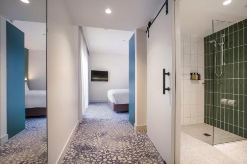 a bathroom with a shower and a walk in shower at Holiday Inn Dandenong by IHG in Dandenong