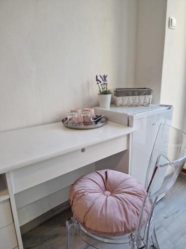 a white desk with a chair and a plate on it at Apartment and Room Marija in Krk