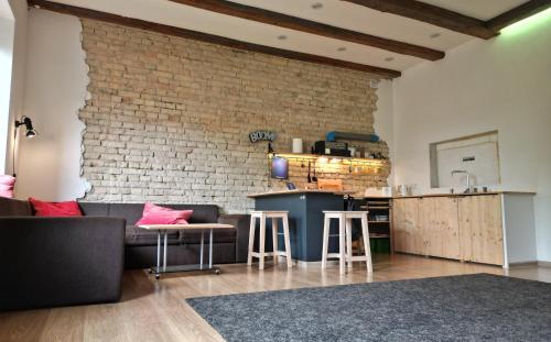 a living room with a couch and a brick wall at 4Work & Leisure EASY SELF-CHECKIN 3Parking CENTRAL STATION DISTRICT - simpletone02 in Vilnius