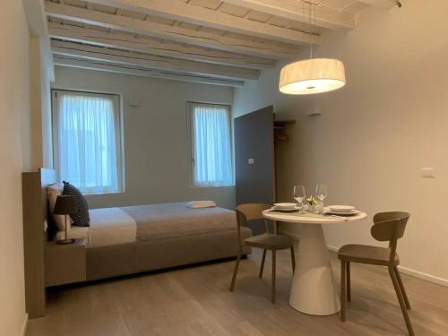 una camera con letto e tavolo con sedie di Residenza SubitoSanto - Appartamento 1A Ruzzante a Padova