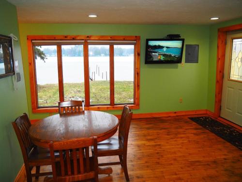 a dining room with a table and chairs and a television at New! The Turk Lake House - Lakefront With Toys! in Greenville