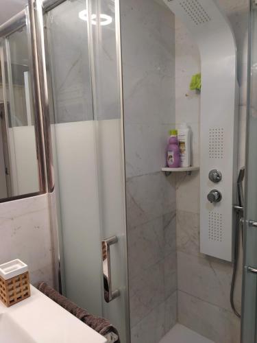 a shower with a glass door in a bathroom at Casita playa in Calafell
