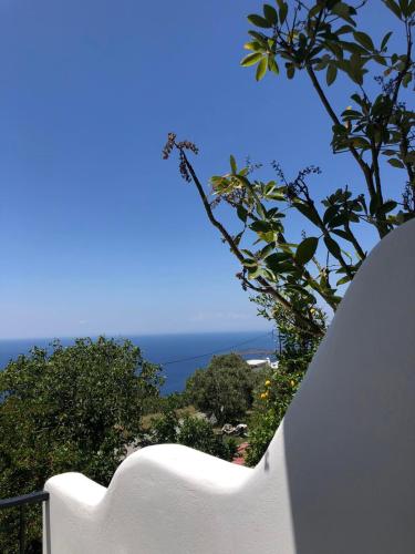 a white railing with a view of the ocean at Vlami's House Andros in Apróvaton