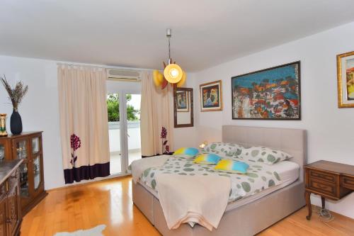 a bedroom with a bed and a table and a window at Apartments and Rooms Anika in Zadar