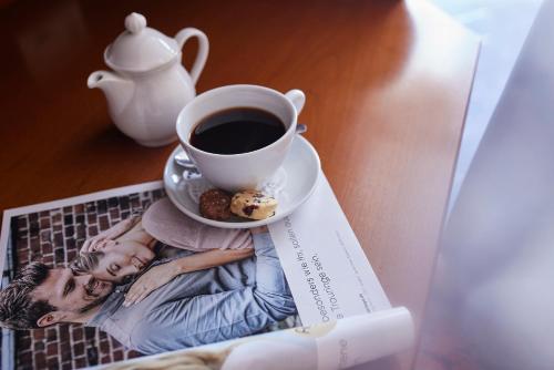 a magazine with a cup of coffee and a plate of donuts at Struck Landhotel & SPA in Attendorn