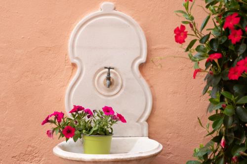 a white shelf with flowers on a wall at Antonios Hostal in Sitges