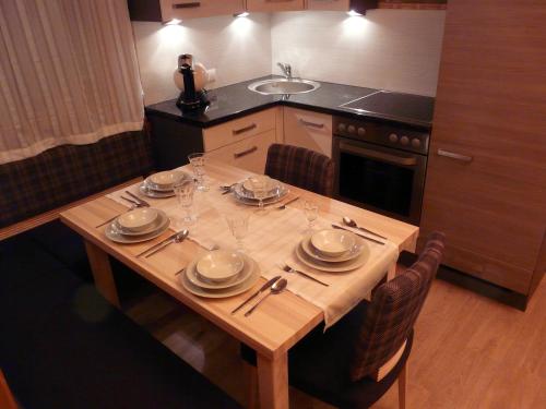 - une table en bois avec des assiettes et des verres dans la cuisine dans l'établissement Ferienhaus Weerberg, à Weerberg