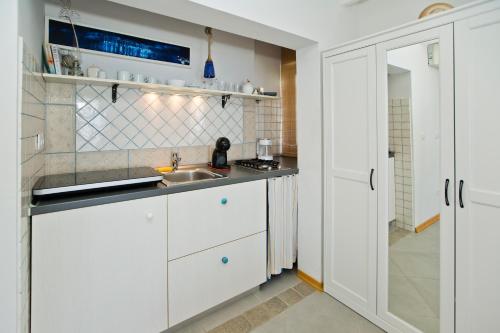 a kitchen with white cabinets and a sink at Rino in Hvar