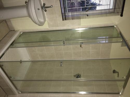 a glass shelf in a bathroom with a sink at Moya Cottage in Underberg