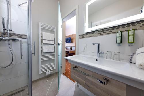 a white bathroom with a sink and a shower at Struck Landhotel & SPA in Attendorn