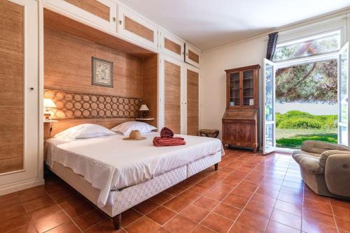 une chambre avec un grand lit et une grande fenêtre dans l'établissement A Casa di Cappelli - Magnifique villa, pieds dans l'eau avec plage privée, à Grosseto-Prugna