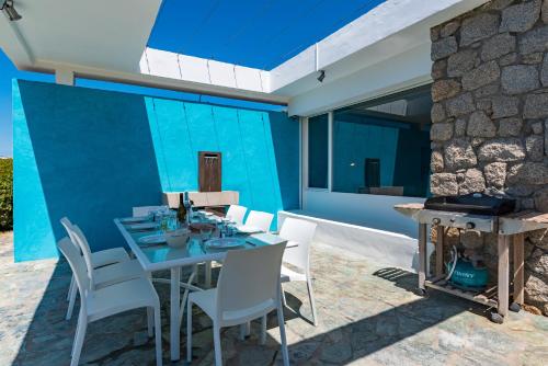 un patio avec une table, des chaises et une cheminée dans l'établissement A Casa di Cappelli - Magnifique villa, pieds dans l'eau avec plage privée, à Grosseto-Prugna