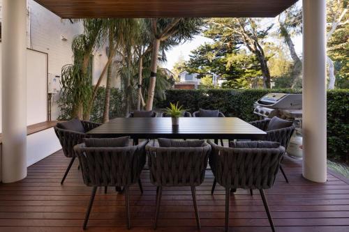 a patio with a table and chairs on a deck at Beach Retreat in Sydney