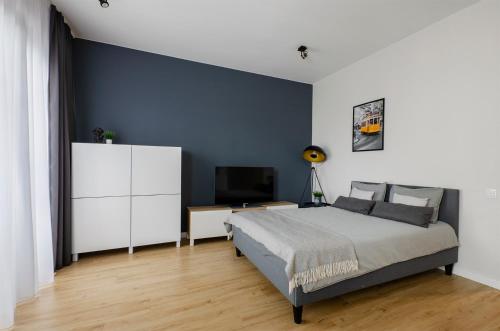 a bedroom with a king sized bed and a television at Apartament Majowy in Łódź