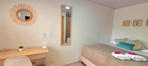 a bedroom with a bed and a desk and a mirror at Colorful Garden House in Providencia