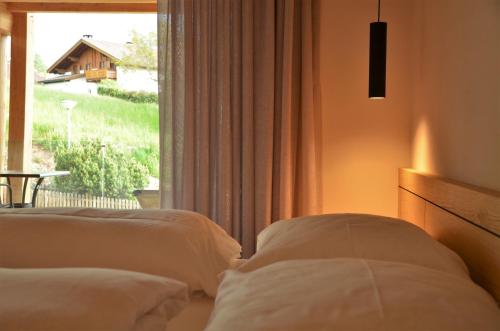 a hotel room with two beds and a window at Kastelart - Karbon in Castelrotto