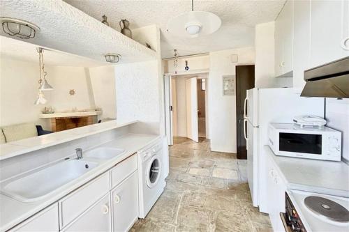 a white kitchen with a sink and a dishwasher at Nemesis House Elani Beach in Elani