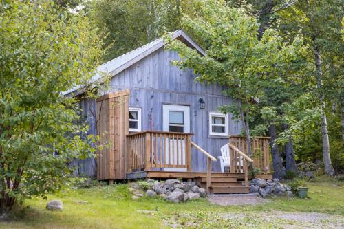 a wooden cabin with a porch and a deck at Trailside Accommodations and Outdoor Adventures in Birch Plain