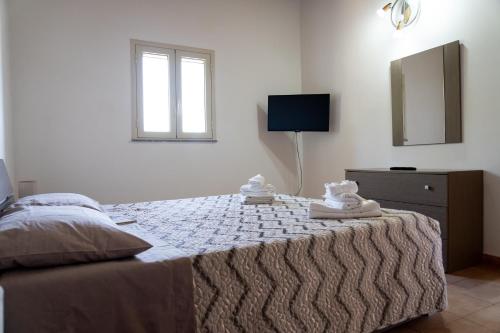 una camera da letto con un letto e asciugamani di B&B L'Uliveto a Marzamemi