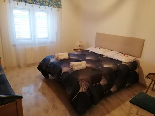 1 dormitorio con 1 cama grande y 2 almohadas en La casa degli ulivi, en Turri