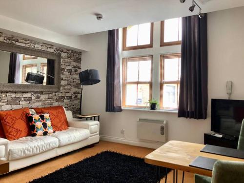 a living room with a couch and a tv at Bank Building Apartments in Barnoldswick