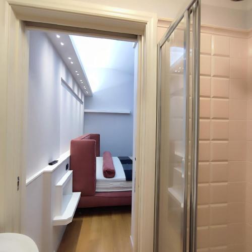 Kleines Zimmer mit einem Bett und einer Glasschiebetür in der Unterkunft GIOIA SEA Apartment In Versilia in Viareggio