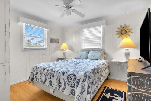 a bedroom with a bed and a ceiling fan at Sunkissed 2 by Oak Island Accommodations in Oak Island