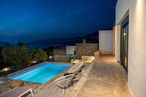 a villa with a swimming pool at night at Casatino Villas in Kalianeika