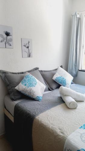 um quarto com uma cama com almofadas azuis e brancas em Casa da Lis pé na areia em Morro de São Paulo