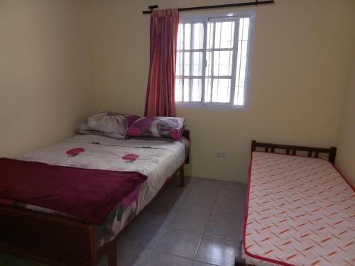 Leandro N. Alem的住宿－Departamento Villa Libertad，一间卧室设有两张床和窗户。