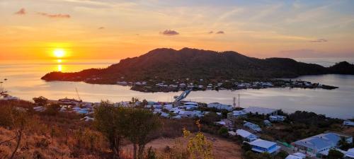 a sunset over a small island in a body of water at Colorful Garden House in Providencia
